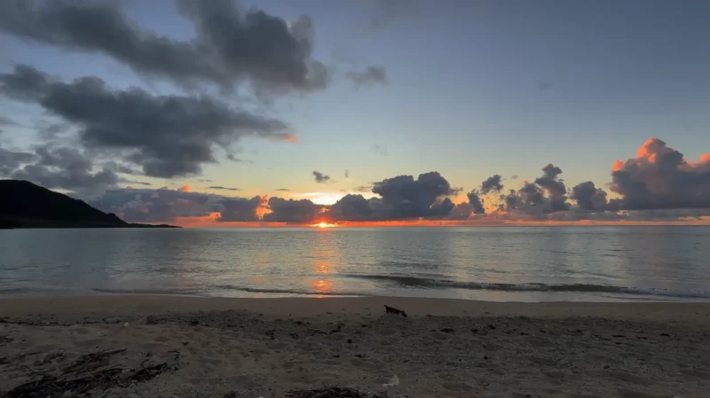 明石海岸から見た朝日 石垣島・明石海岸で朝日に染まる海と浜辺