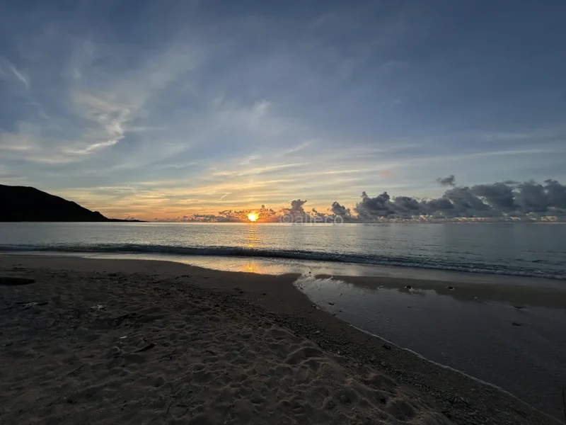 朝日に照らされる明石海岸 明石海岸の海と砂浜を照らす朝日
